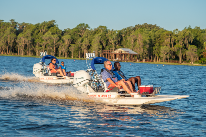 a group of people riding on the back of a boat in the water